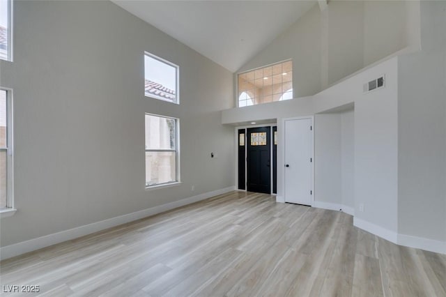 foyer with visible vents, baseboards, high vaulted ceiling, and light wood-style floors