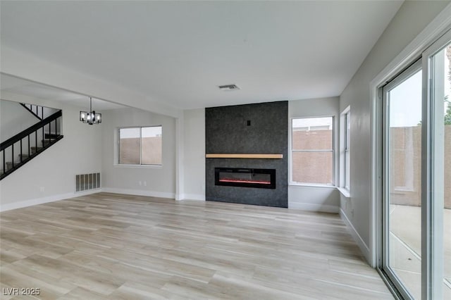 unfurnished living room featuring visible vents, stairway, a fireplace, and baseboards