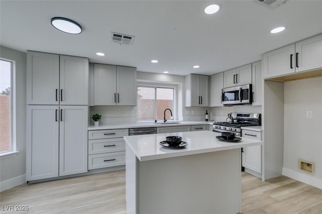 kitchen featuring a sink, visible vents, stainless steel appliances, light countertops, and baseboards