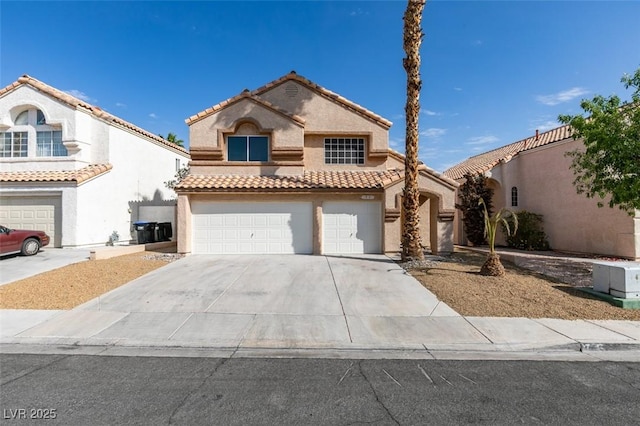 mediterranean / spanish house with concrete driveway, stucco siding, a tiled roof, and an attached garage