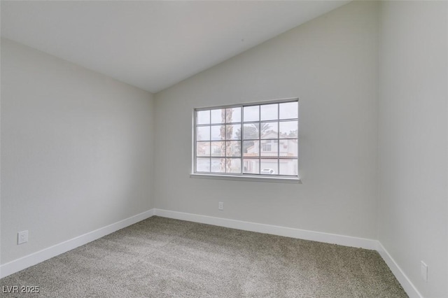 empty room featuring baseboards, carpet, and lofted ceiling