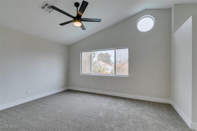 spare room featuring carpet flooring, ceiling fan, visible vents, baseboards, and vaulted ceiling