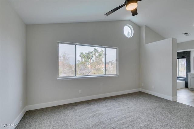 spare room featuring lofted ceiling, a ceiling fan, light colored carpet, and visible vents