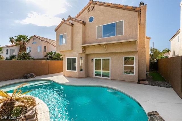 back of house featuring a fenced in pool, stucco siding, a fenced backyard, and a patio area