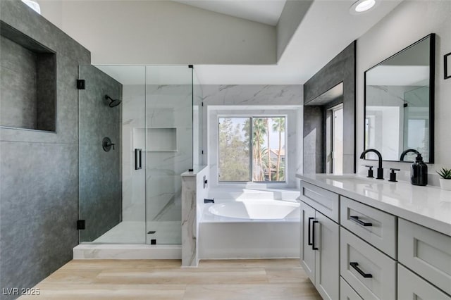 full bath featuring a stall shower, a bath, wood finished floors, and vanity