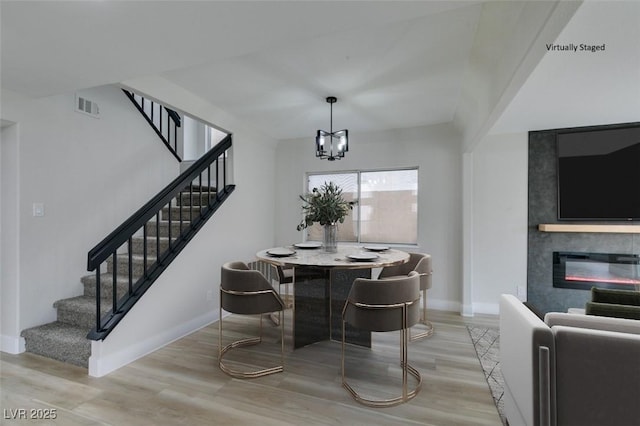 dining area with light wood-style floors, visible vents, stairs, and baseboards