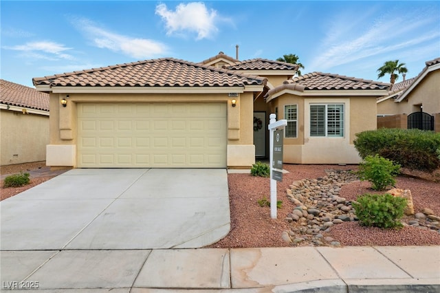 mediterranean / spanish home with an attached garage, stucco siding, concrete driveway, and central AC