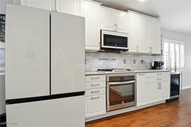 kitchen featuring light countertops, white cabinets, stainless steel appliances, and dark wood finished floors