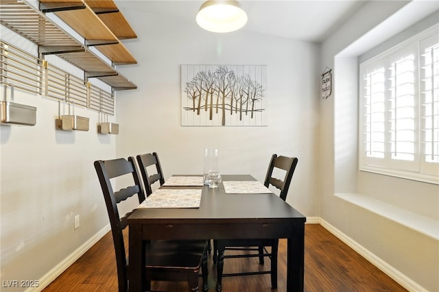 dining space featuring baseboards and wood finished floors