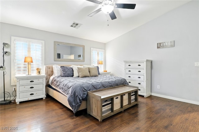 bedroom with baseboards, visible vents, dark wood finished floors, and vaulted ceiling