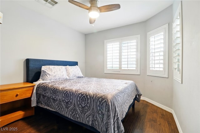bedroom featuring baseboards, ceiling fan, wood finished floors, and visible vents