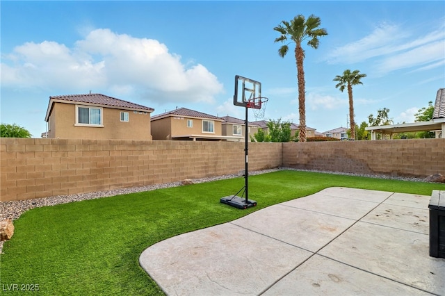 view of sport court featuring a lawn and a fenced backyard