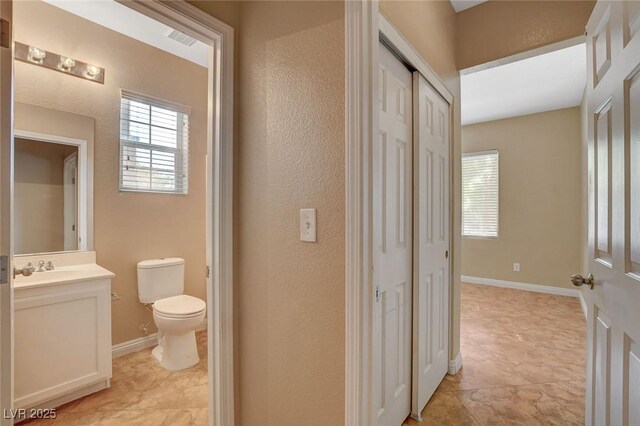 8988 Winchester Ridge St, Las Vegas, NV 89139 - bathroom featuring vanity, toilet, visible vents, a textured wall, and baseboards
