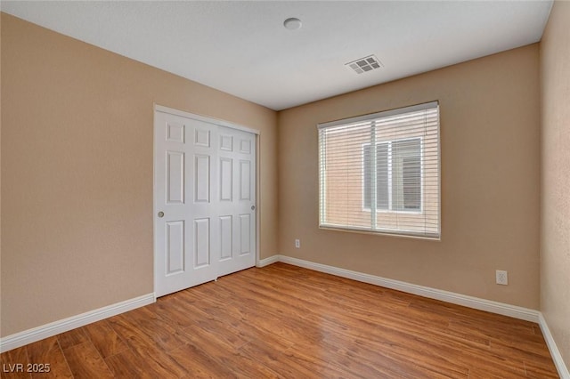 8988 Winchester Ridge St, Las Vegas, NV 89139 - unfurnished bedroom with a closet, visible vents, wood finished floors, and baseboards
