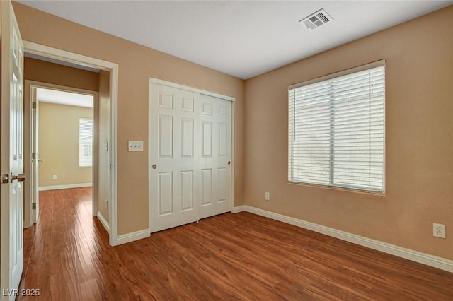 8988 Winchester Ridge St, Las Vegas, NV 89139 - unfurnished bedroom with baseboards, visible vents, wood finished floors, and a closet