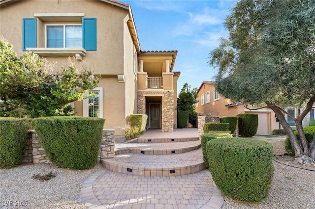 1265 Vietti St, Henderson, NV 89012 - view of front facade featuring stucco siding, a balcony, stone siding, and a tiled roof