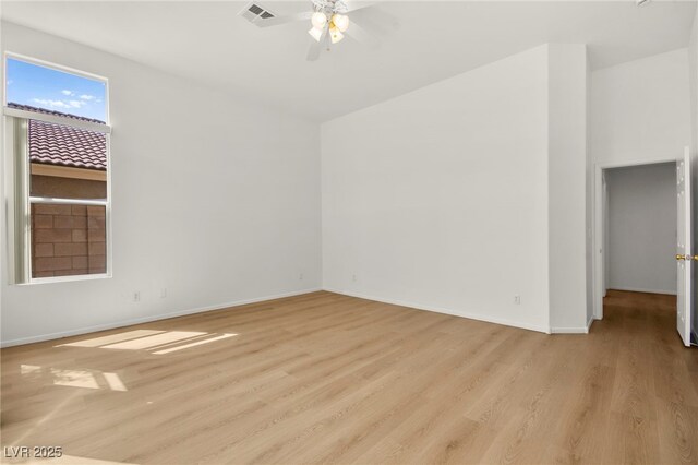 spare room featuring a ceiling fan, baseboards, visible vents, and wood finished floors