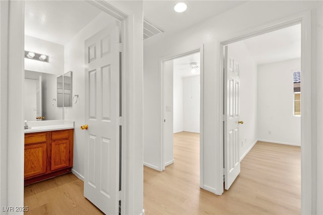 hallway with baseboards and light wood-style flooring