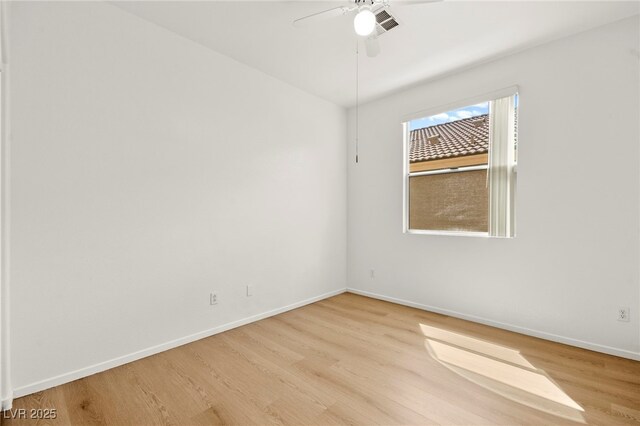 spare room with a ceiling fan, baseboards, and wood finished floors