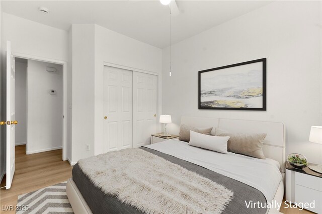 bedroom featuring light wood-style floors, baseboards, and a closet