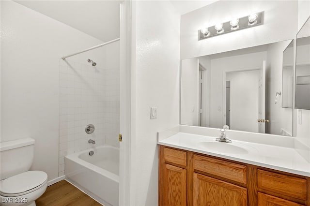 bathroom with toilet, shower / tub combination, wood finished floors, and vanity