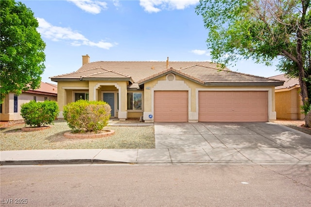 ranch-style home with driveway, a chimney, a tile roof, an attached garage, and stucco siding