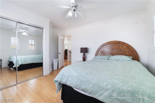 bedroom featuring ceiling fan, ornamental molding, wood finished floors, and a closet