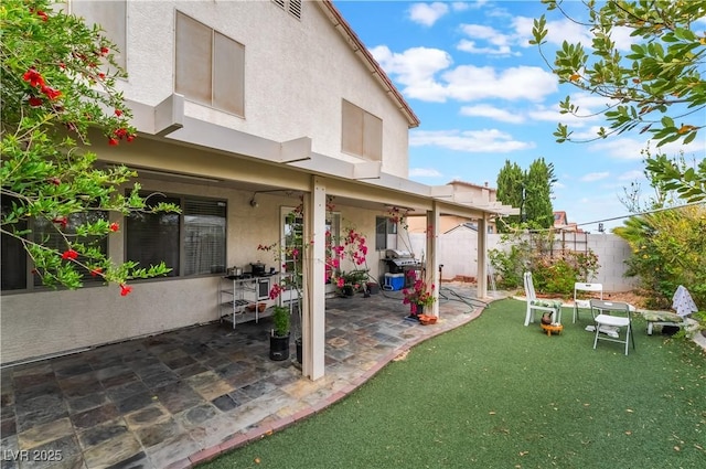 exterior space featuring a fenced backyard, a patio, stucco siding, and a yard
