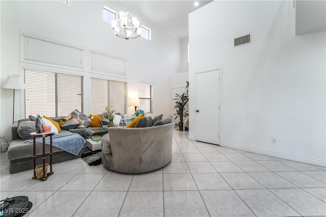 living area with a high ceiling, a chandelier, a healthy amount of sunlight, light tile patterned floors, and visible vents