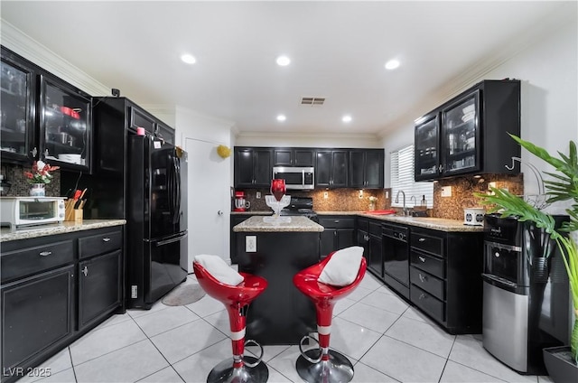 kitchen featuring dark cabinets, ornamental molding, a toaster, and black appliances