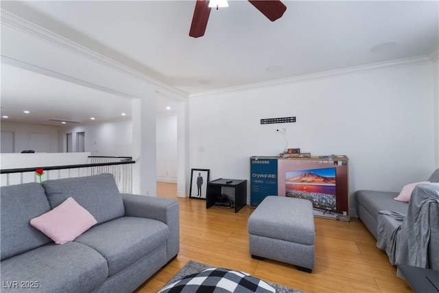 living room featuring crown molding, ceiling fan, and light wood-style flooring