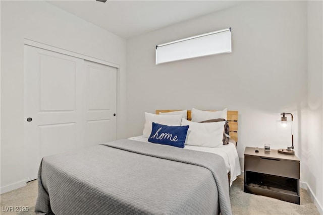 carpeted bedroom with baseboards and a closet