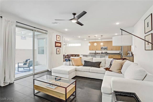 living area featuring dark tile patterned flooring, visible vents, ceiling fan, and recessed lighting