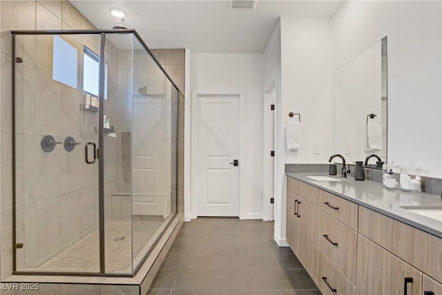 full bath with a shower stall, double vanity, and a sink