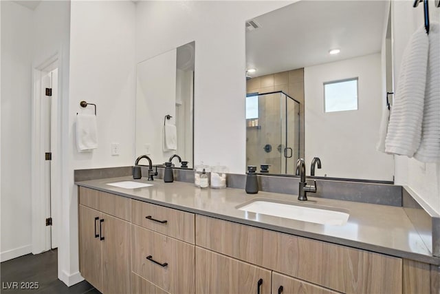 bathroom with a shower stall, visible vents, double vanity, and a sink