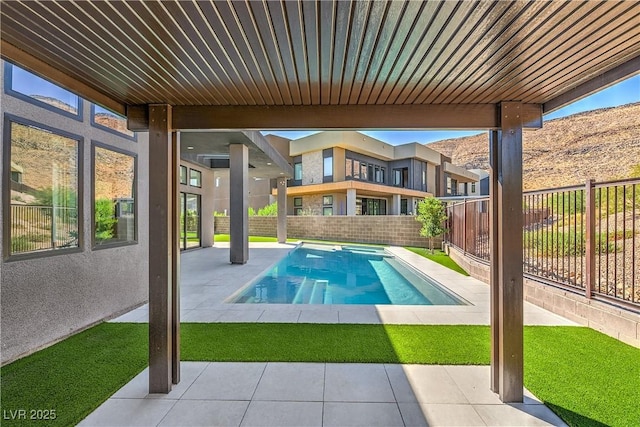 view of pool with a patio area, a pool with connected hot tub, and a fenced backyard