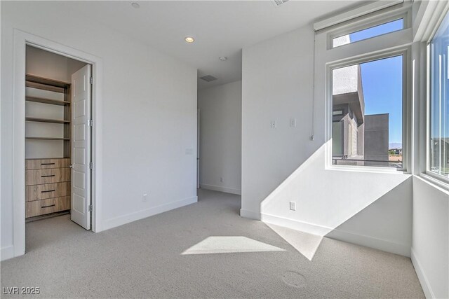 unfurnished bedroom featuring recessed lighting, visible vents, baseboards, carpet floors, and a spacious closet