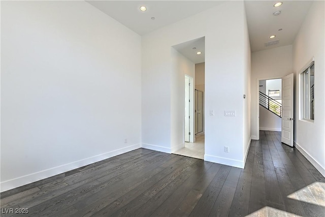 empty room featuring recessed lighting, visible vents, baseboards, and dark wood-type flooring