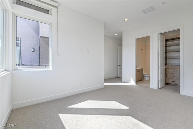 unfurnished bedroom featuring baseboards, visible vents, and light colored carpet