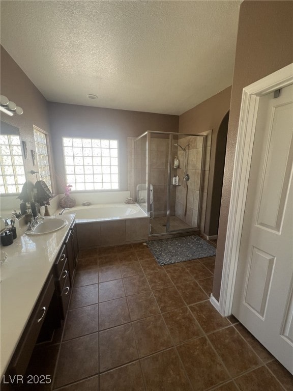 6596 Secluded Ave, Las Vegas, NV 89110 - bathroom featuring a textured ceiling, a bath, a shower stall, double vanity, and tile patterned floors