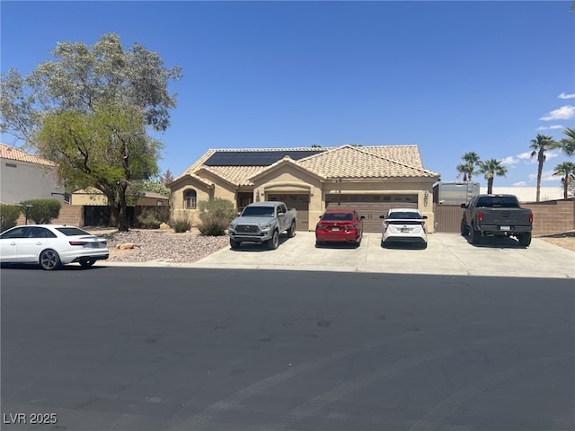 6596 Secluded Ave, Las Vegas, NV 89110 - view of front facade featuring concrete driveway, a garage, a tile roof, stucco siding, and roof mounted solar panels