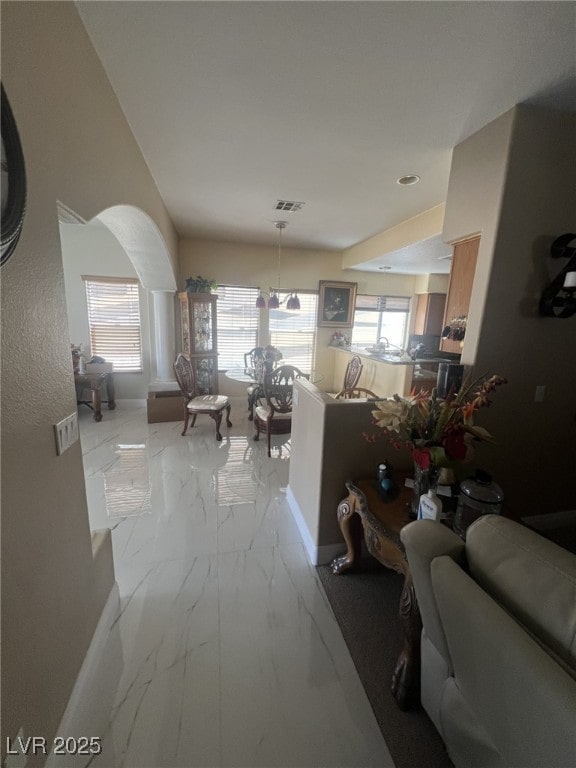 6596 Secluded Ave, Las Vegas, NV 89110 - hall with light marble finish flooring, arched walkways, and baseboards