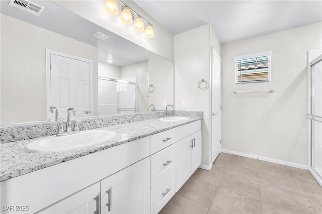 9198 Rolling Sky Dr, Las Vegas, NV 89178 - bathroom featuring a stall shower, baseboards, double vanity, and tile patterned flooring