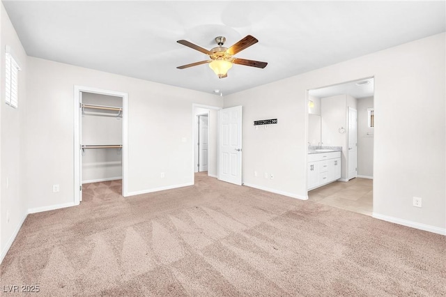 9198 Rolling Sky Dr, Las Vegas, NV 89178 - unfurnished bedroom with light carpet, baseboards, a spacious closet, and ensuite bath