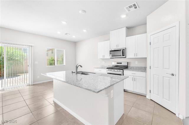 9198 Rolling Sky Dr, Las Vegas, NV 89178 - kitchen featuring stainless steel appliances, a sink, light tile patterned flooring, a center island with sink, and white cabinetry