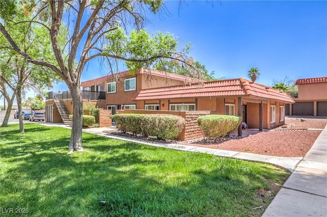 250 Shadybrook Ln Unit D, Las Vegas, NV 89107 - view of front of home with a front lawn, stucco siding, stairway, and a tile roof