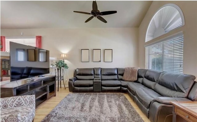 living room featuring lofted ceiling, a healthy amount of sunlight, a ceiling fan, and light wood-style flooring
