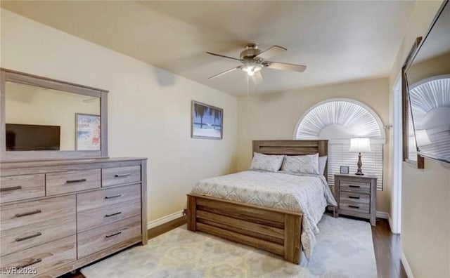 bedroom with baseboards, light wood-type flooring, and a ceiling fan