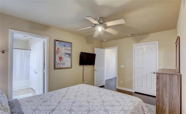 bedroom featuring visible vents, ensuite bathroom, a ceiling fan, and baseboards
