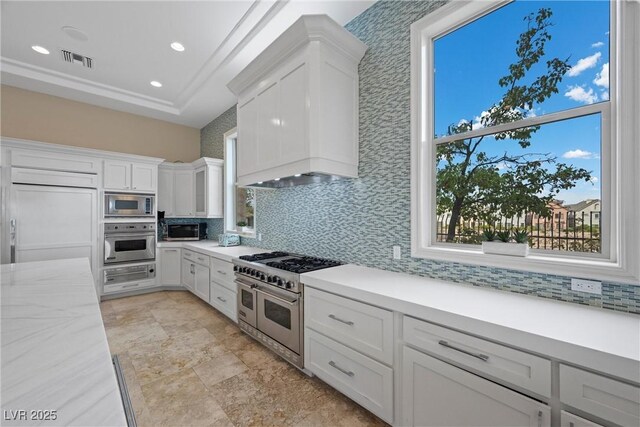 9301 Verlaine Ct, Las Vegas, NV 89145 - kitchen with built in appliances, visible vents, custom exhaust hood, decorative backsplash, and white cabinets